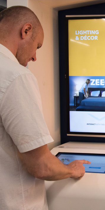 Homme interagissant avec un écran tactile dans le cadre d'une démonstration de produit interactive alimentée par BrightSign