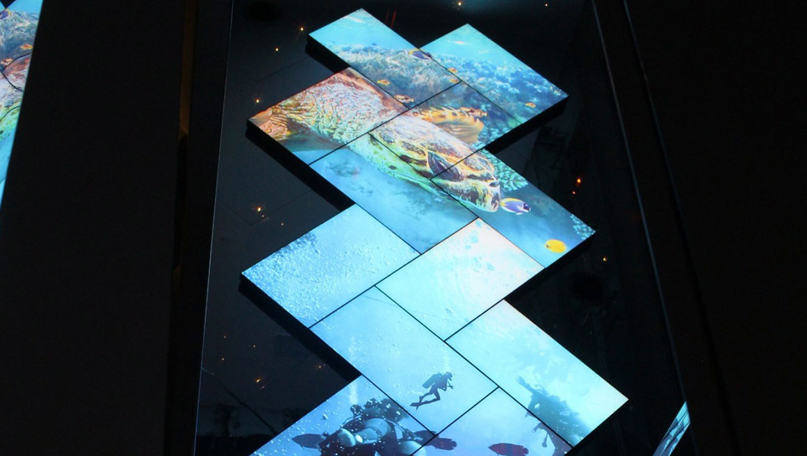 conception géométrique d'écrans numériques utilisant la technologie BrightSign pour afficher l'expérience de la plongée en eaux profondes