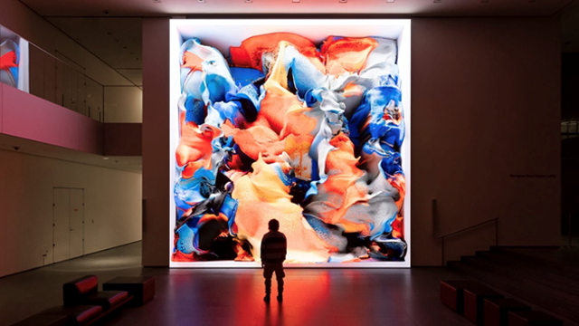 Person standing in front of a floor-to-ceiling video wall, displaying an immersive presentation powered by the BrightSign XC5