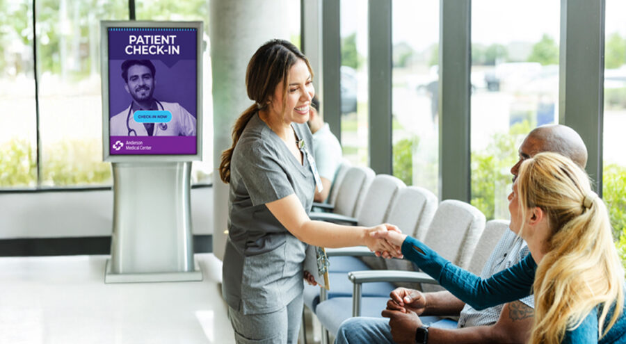 护士与候诊室数字标牌前的患者