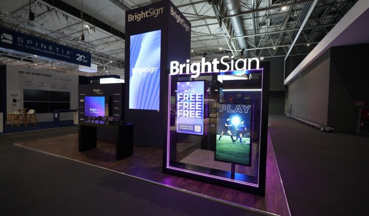 Wide angle shot of a BrightSign booth at a tradeshow with multiple digital displays on the walls